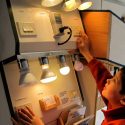 A child learning about light bulbs and their difference in wattage.